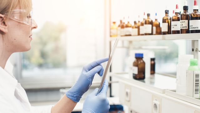 A lab worker holding an ipad.