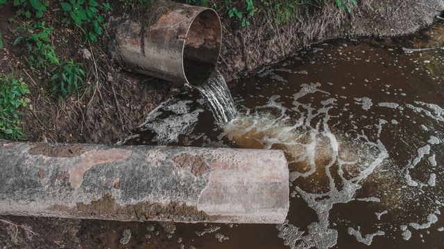 Polluted water flooding out of pipe